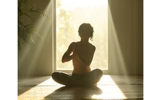 Eine Person, die Yoga in einer ruhigen, von Morgensonne durchfluteten Umgebung praktiziert, vermittelt Ruhe und Achtsamkeit.